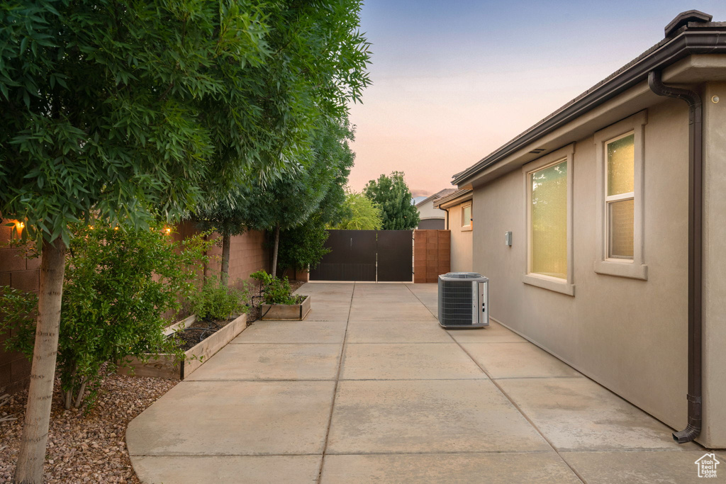 Fenced backyard featuring central AC unit and a patio