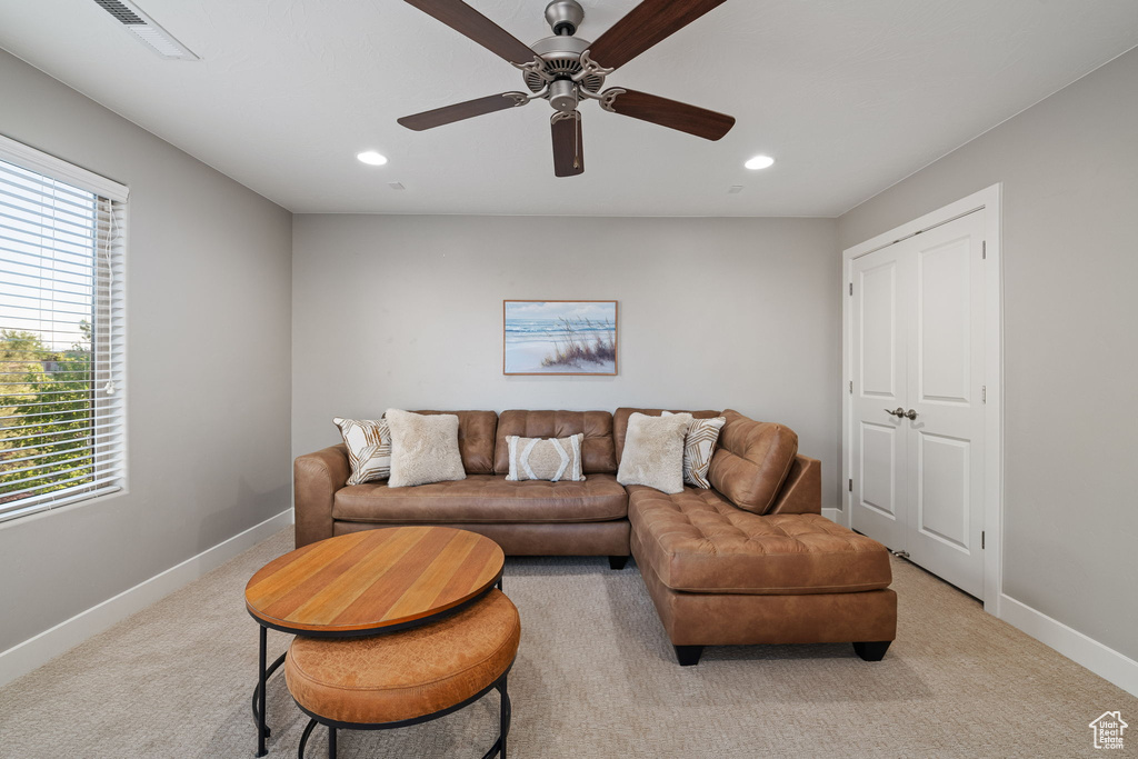 Living room featuring plenty of natural light, light colored carpet, baseboards, and recessed lighting