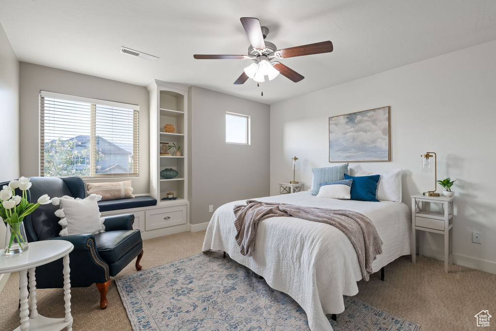 Bedroom with light colored carpet, ceiling fan, and baseboards