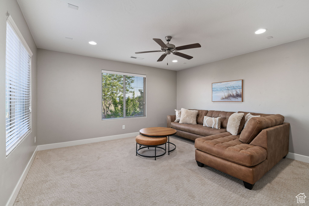 Living room with light colored carpet, baseboards, a ceiling fan, and recessed lighting