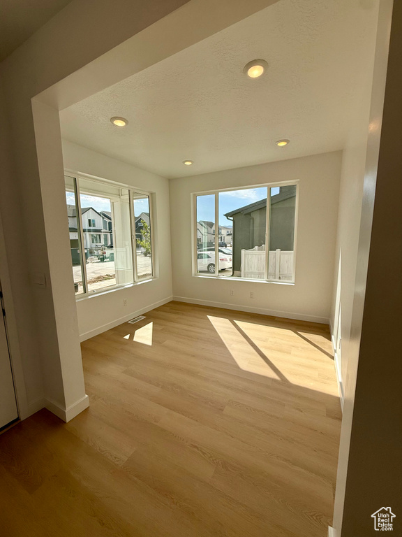 Empty room featuring light wood finished floors and recessed lighting