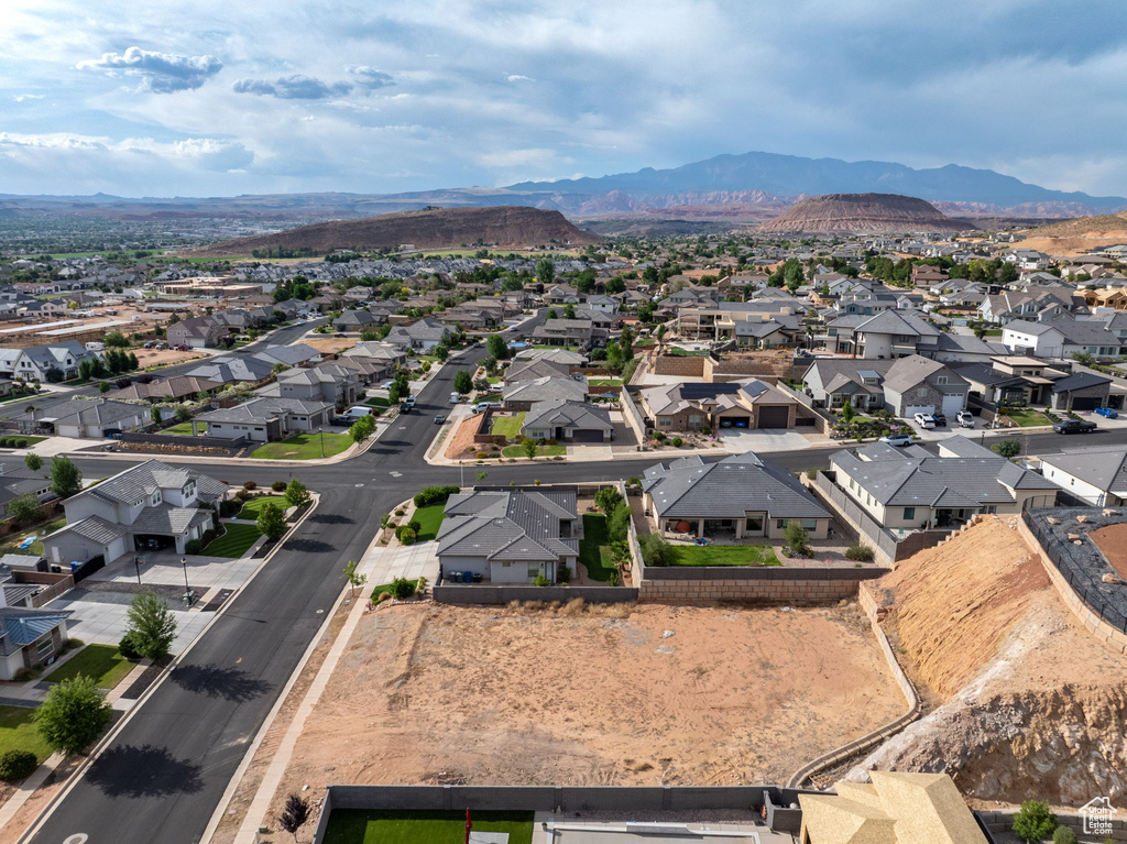 Aerial view of property and surrounding area with nearby suburban area and a mountainous background