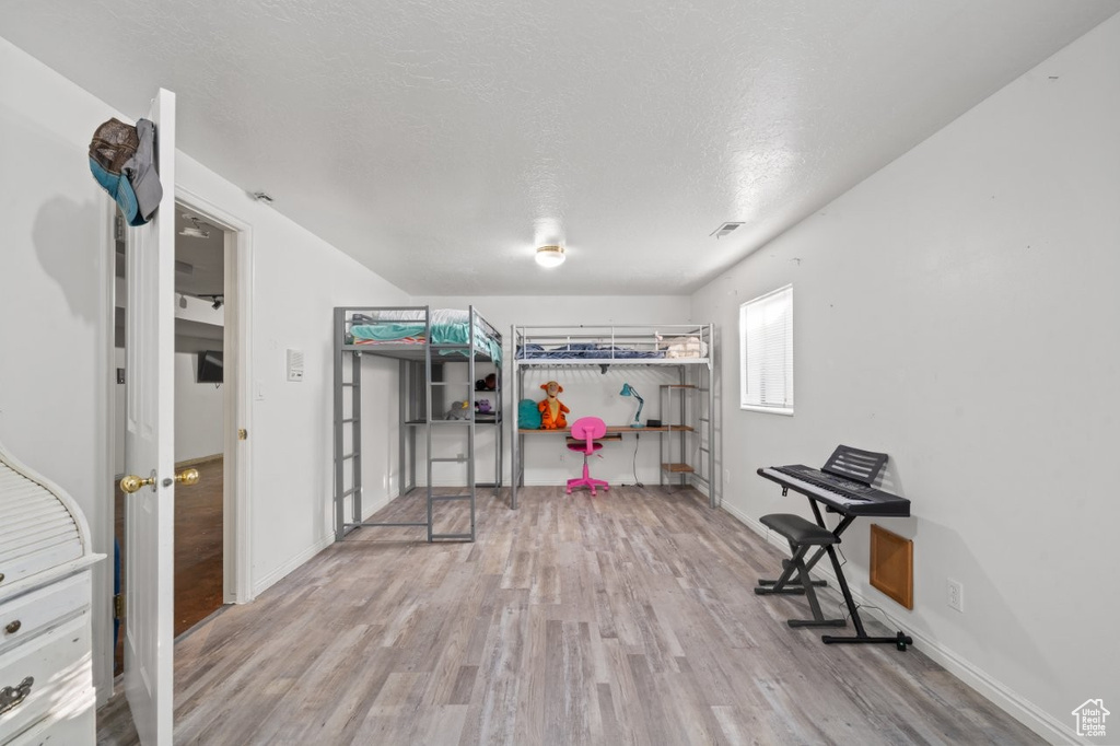 Bedroom featuring wood finished floors, baseboards, and a textured ceiling