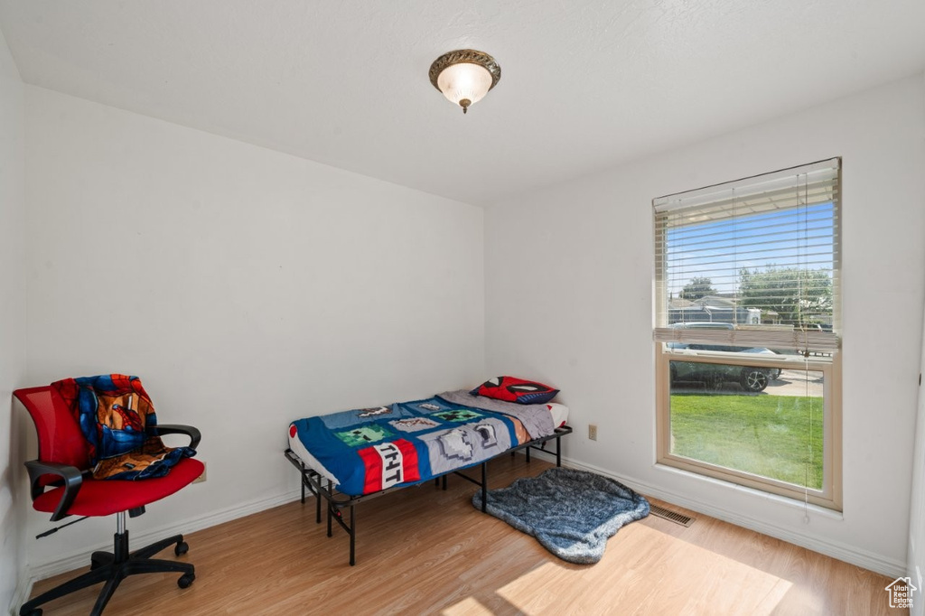 Bedroom with wood finished floors and baseboards