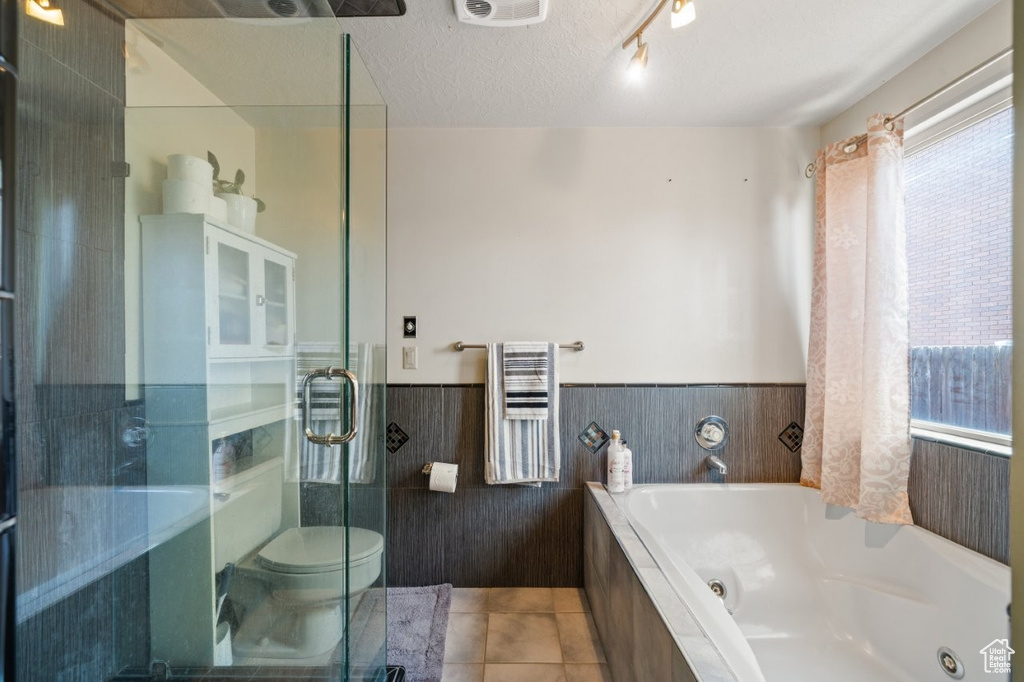Bathroom with radiator, a whirlpool tub, toilet, wainscoting, and a stall shower