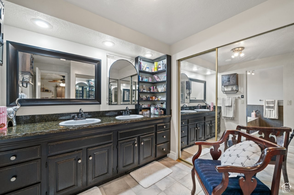Full bath featuring double vanity and tile patterned floors