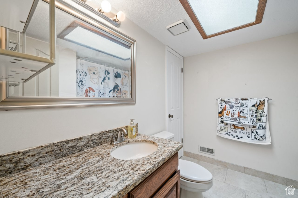 Full bath featuring vanity, toilet, tile patterned flooring, baseboards, and a shower with curtain