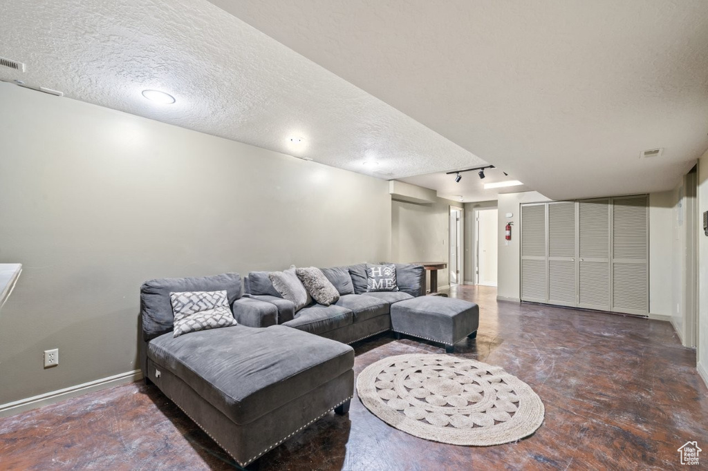 Living area with a textured ceiling and baseboards
