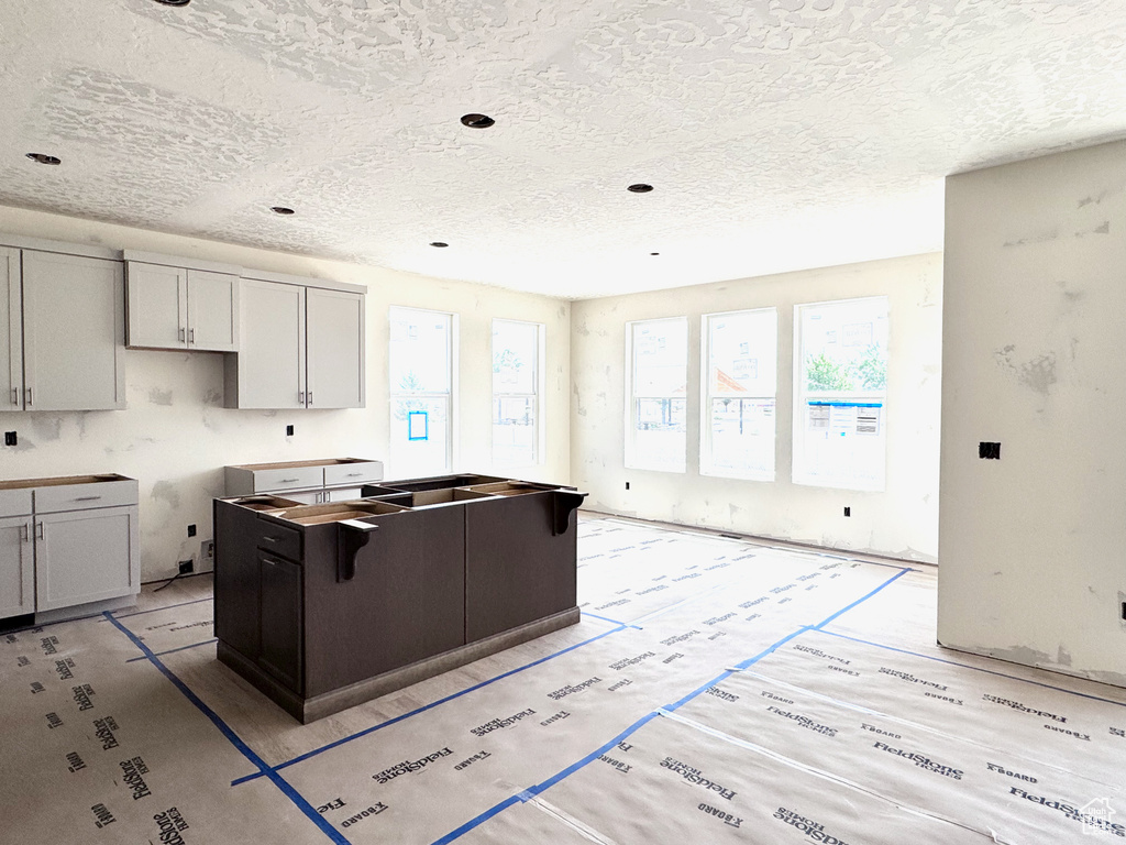 Kitchen with healthy amount of natural light, a textured ceiling, and a kitchen island