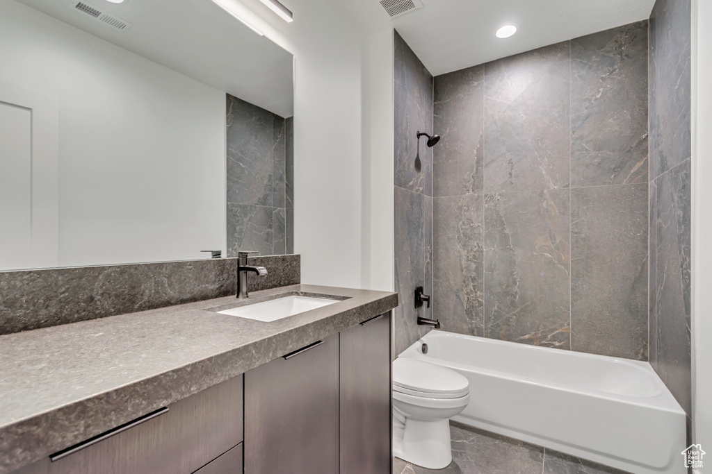 Bathroom with toilet, vanity, tub / shower combination, and recessed lighting