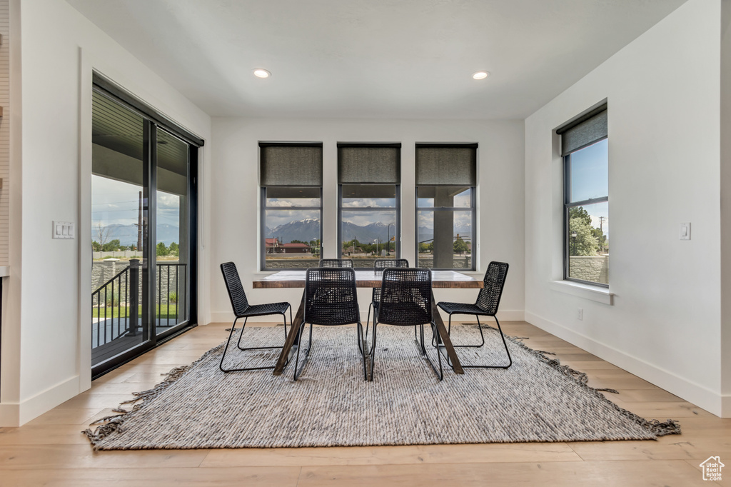 Dining area with plenty of natural light, wood finished floors, baseboards, and recessed lighting