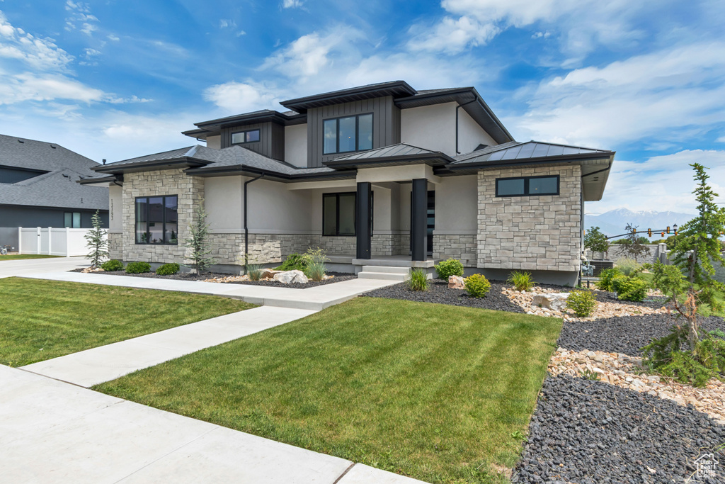 Prairie-style house featuring stone siding, a standing seam roof, and stucco siding