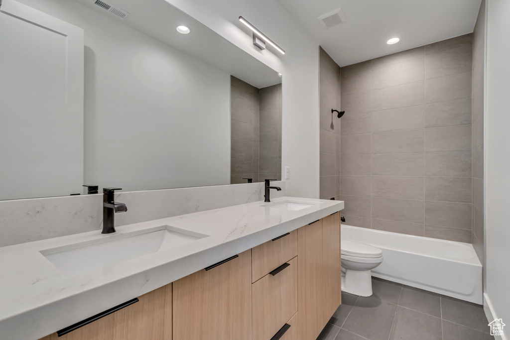 Full bathroom with toilet, tile patterned floors, double vanity, recessed lighting, and shower / tub combination