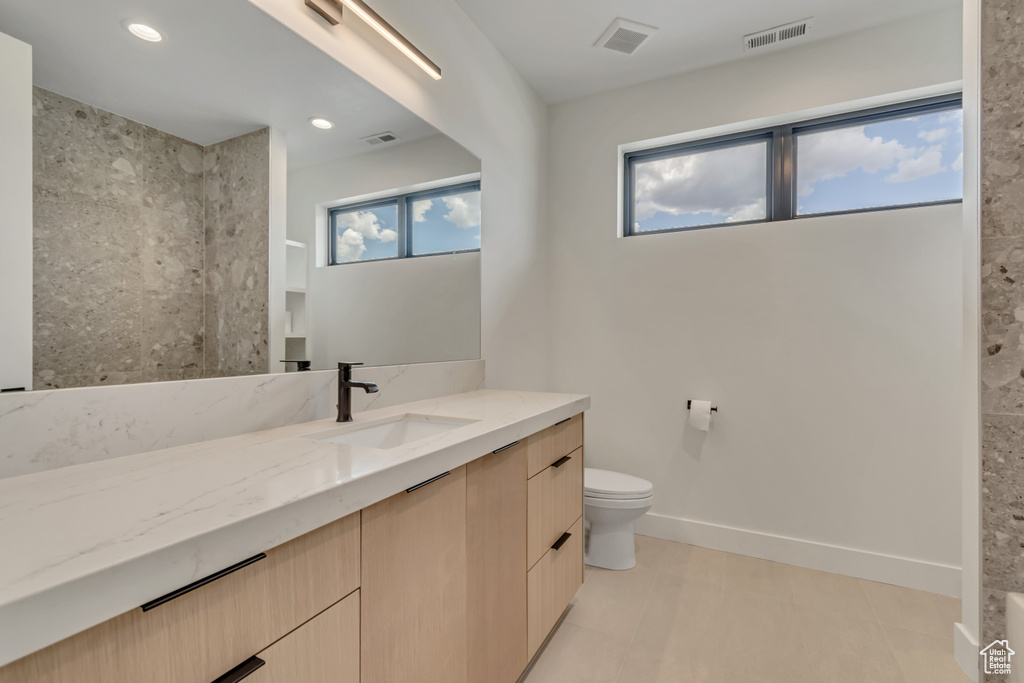 Full bathroom featuring vanity, toilet, a shower, and recessed lighting