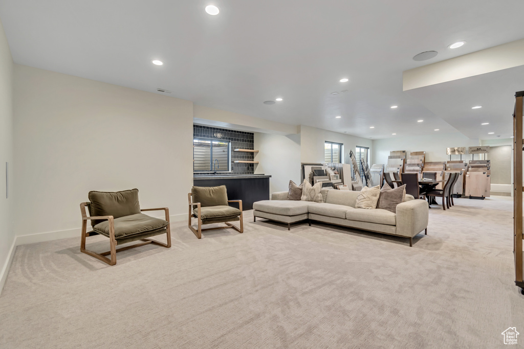 Living area with light colored carpet, recessed lighting, and baseboards