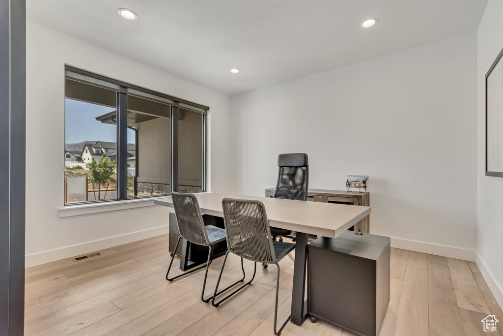 Home office featuring baseboards, light wood-style floors, and recessed lighting