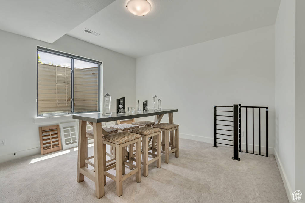 Dining room featuring light colored carpet and baseboards