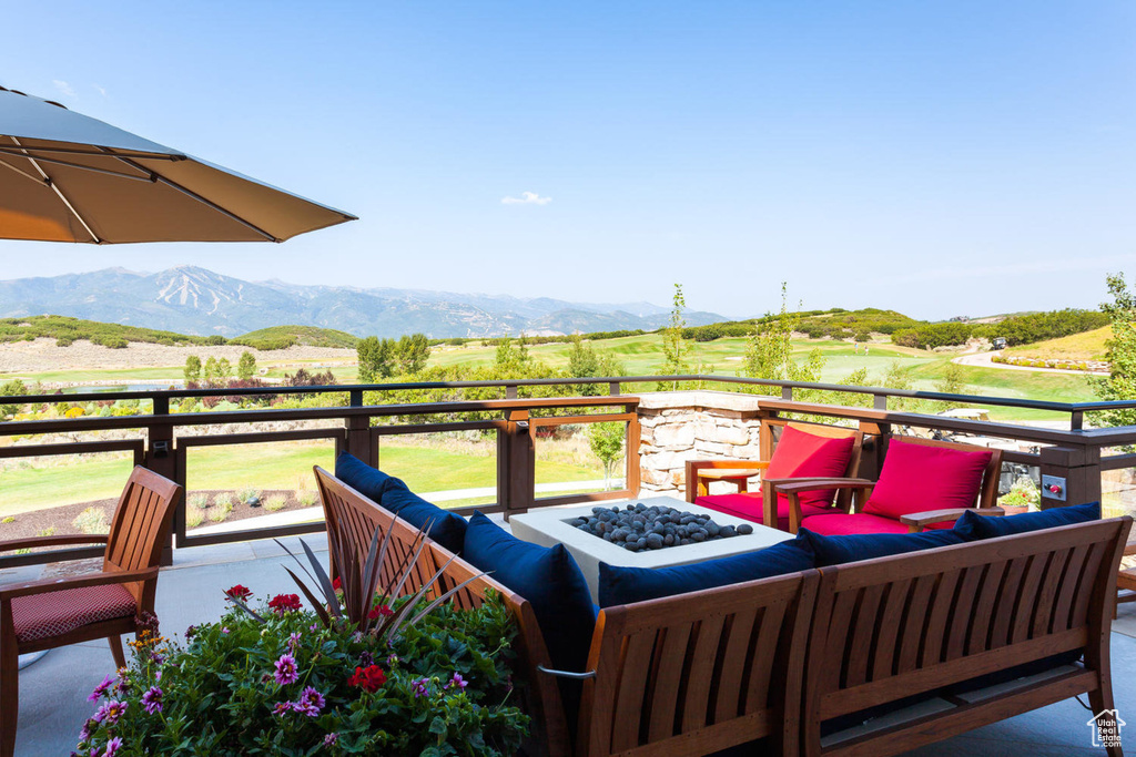 Wooden deck with an outdoor living space with a fire pit and a mountain view