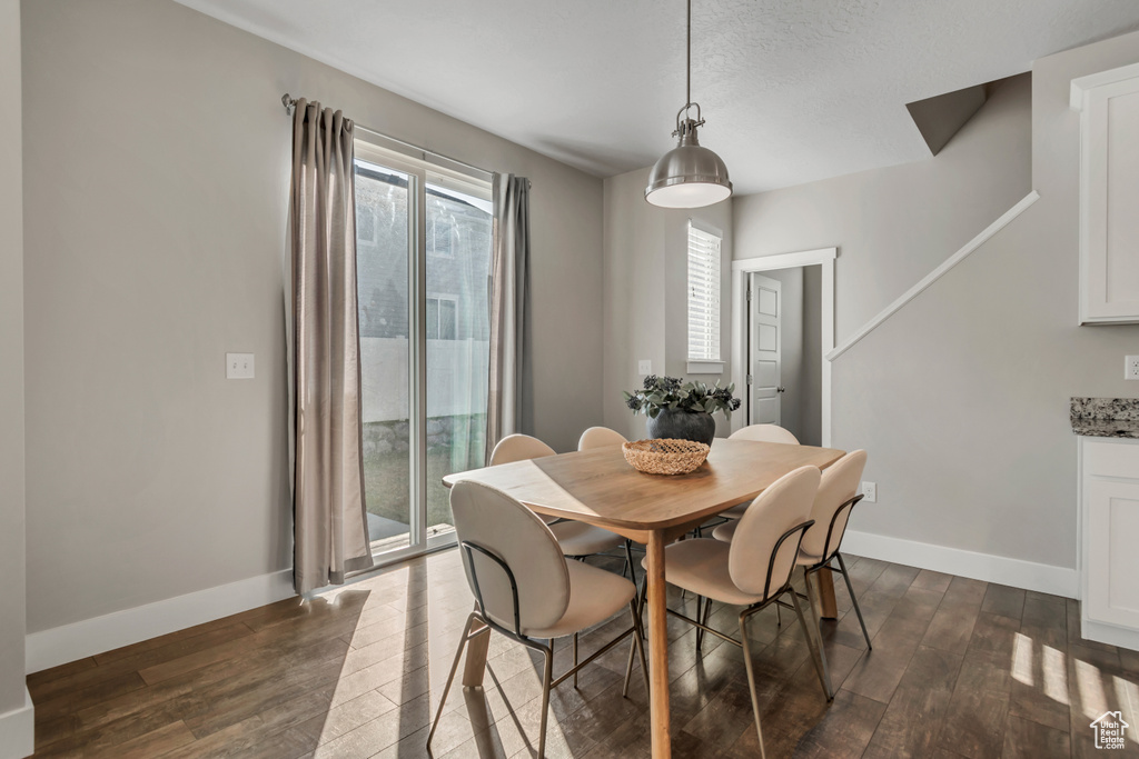 Dining space featuring dark wood finished floors and baseboards