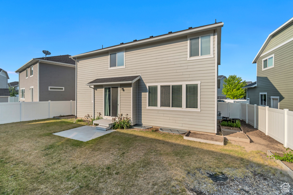 Rear view of property with a garden and a patio