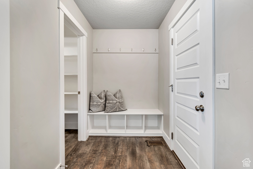 Mudroom with wood finished floors, a textured ceiling, and baseboards