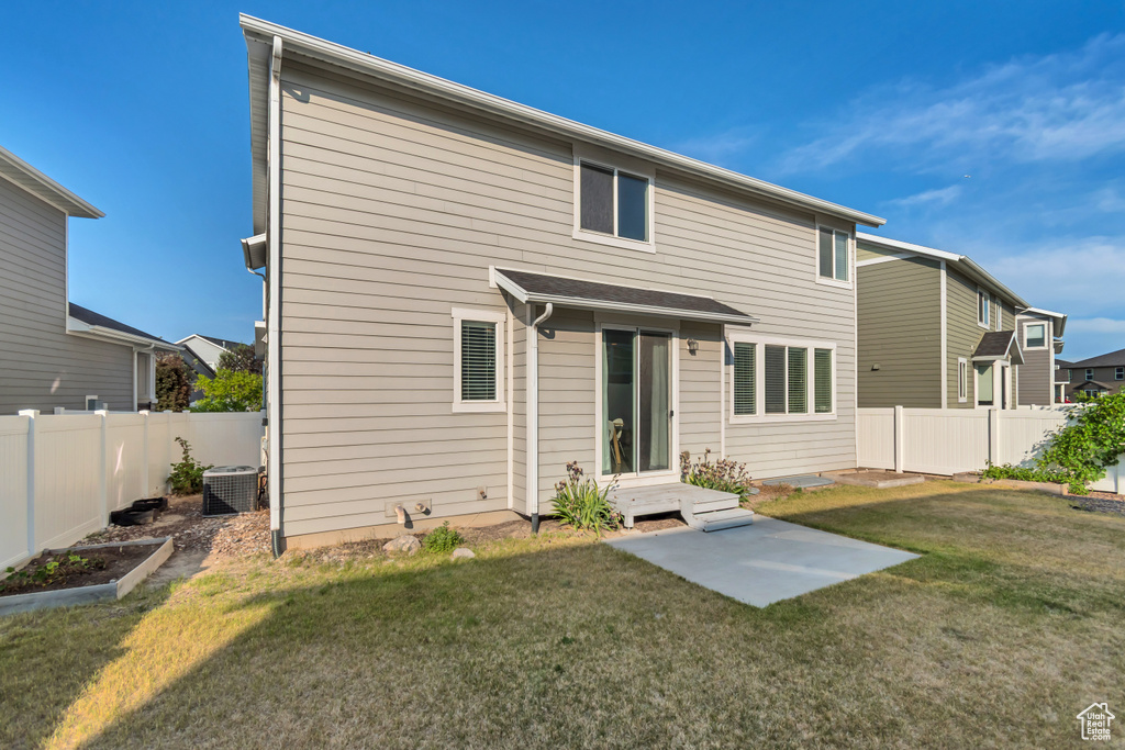 Rear view of house featuring central air condition unit and a vegetable garden