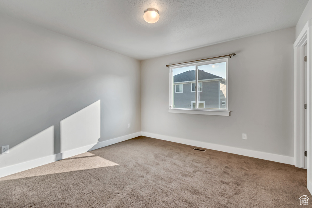 Carpeted empty room featuring baseboards