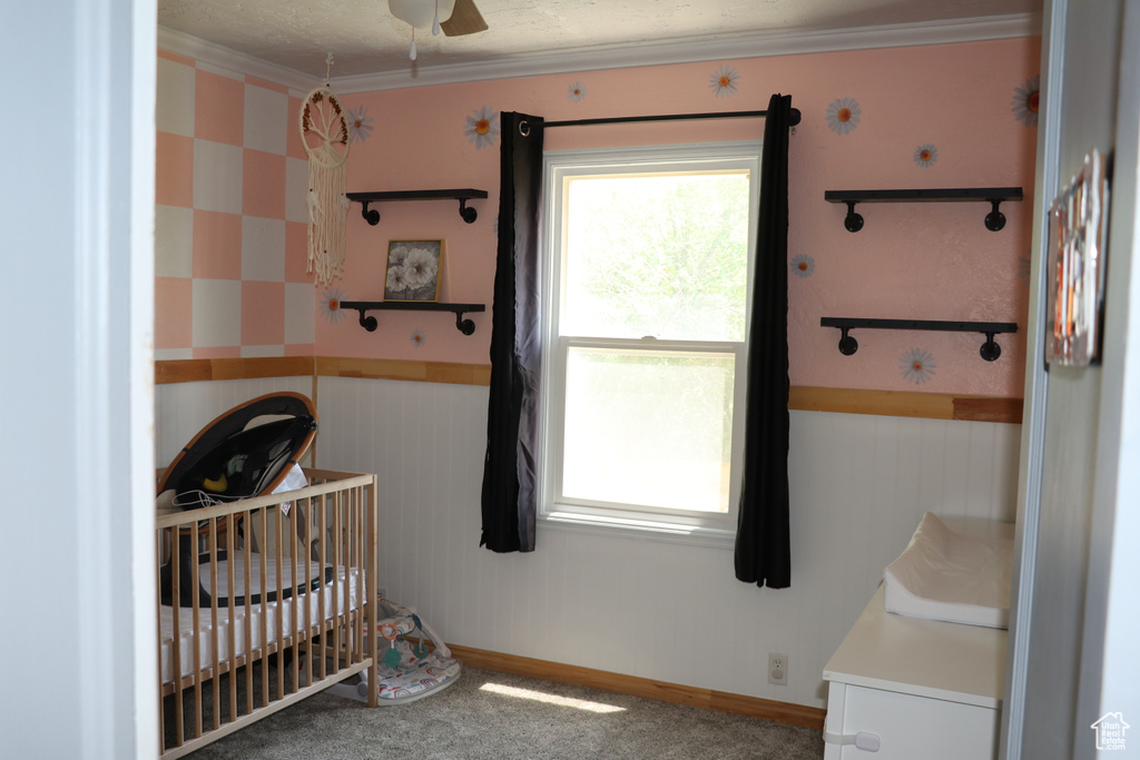 Carpeted bedroom with a nursery area and crown molding