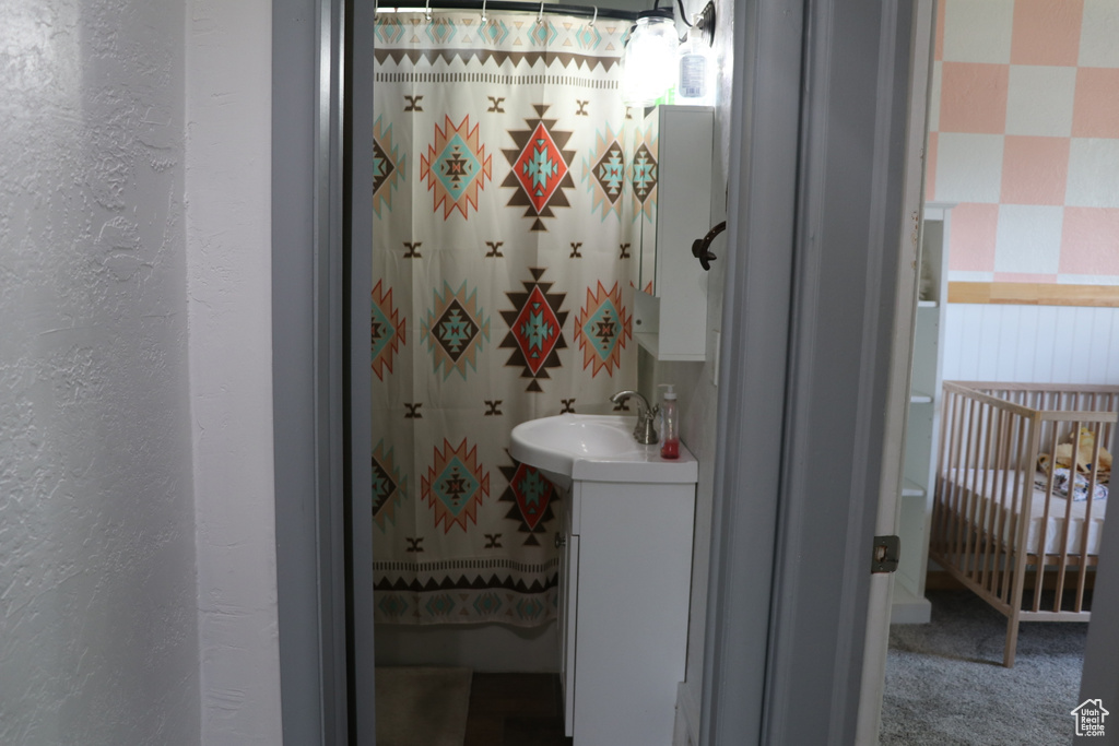Bathroom featuring vanity, a textured wall, and a shower with shower curtain