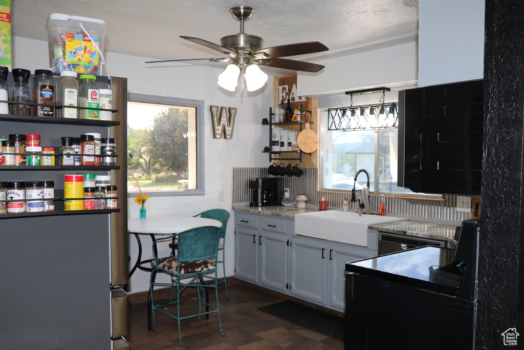 Kitchen featuring a sink, ceiling fan, open shelves, and light countertops