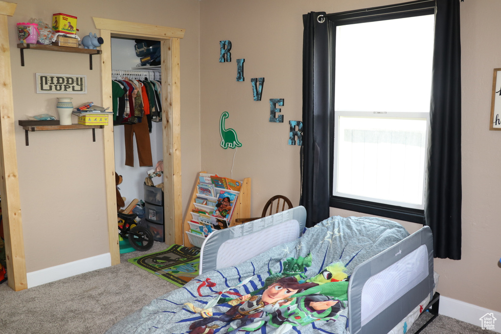 Bedroom with carpet floors, baseboards, and a closet