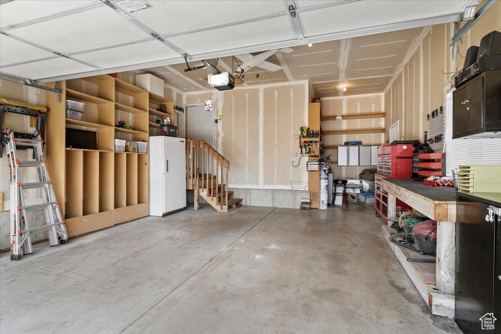 Garage with a garage door opener and a workshop area