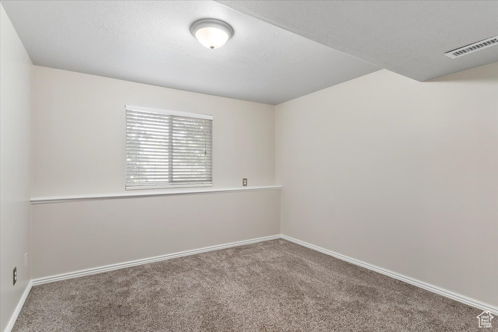 Empty room featuring carpet and baseboards