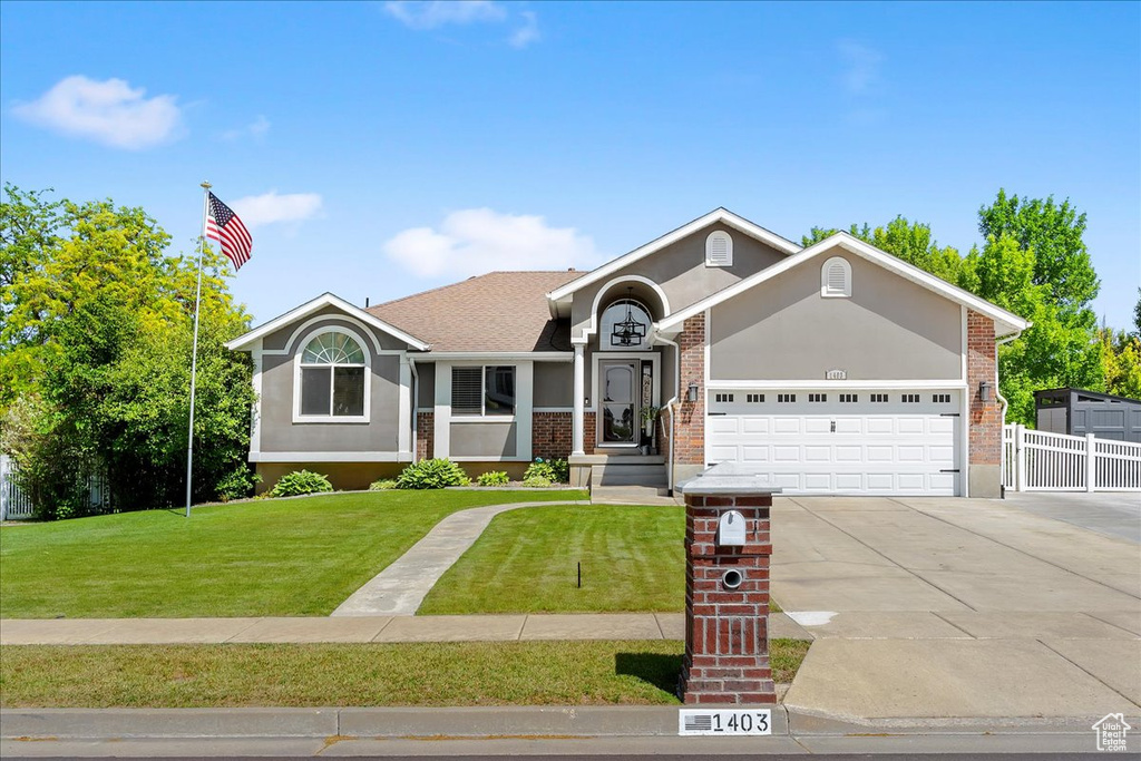 Ranch-style home with driveway, a garage, stucco siding, and brick siding