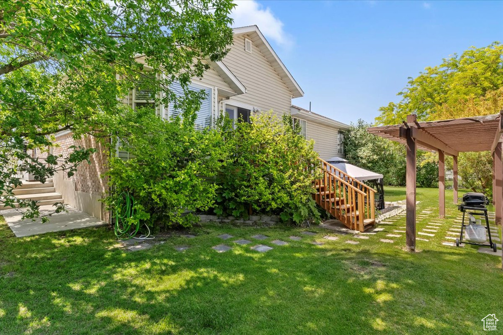 View of green lawn with stairs and a pergola