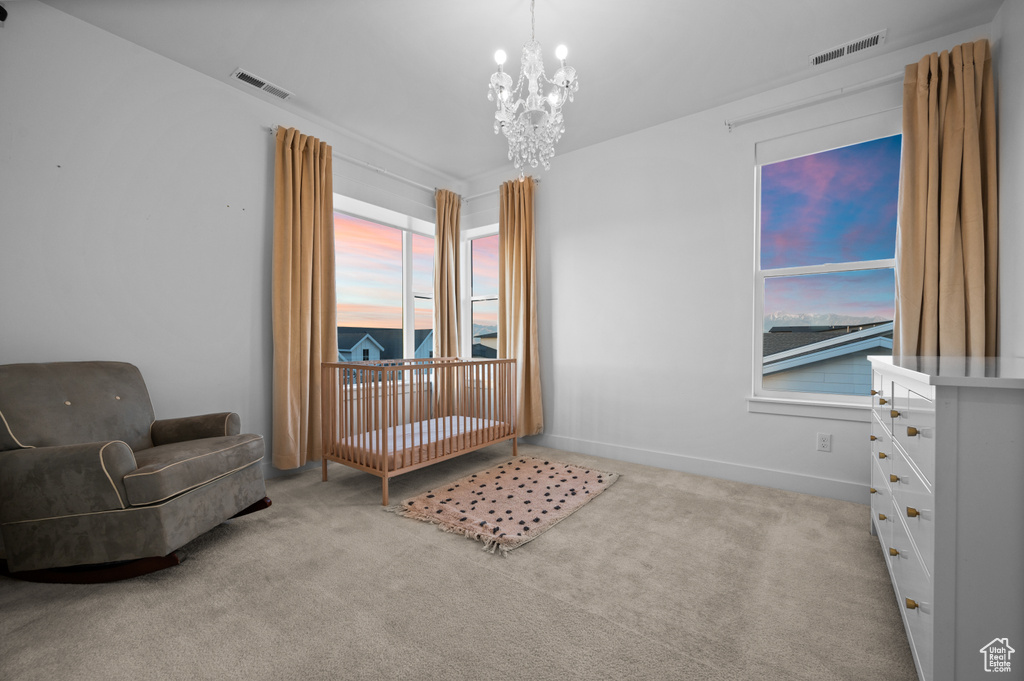 Carpeted bedroom featuring a chandelier and baseboards