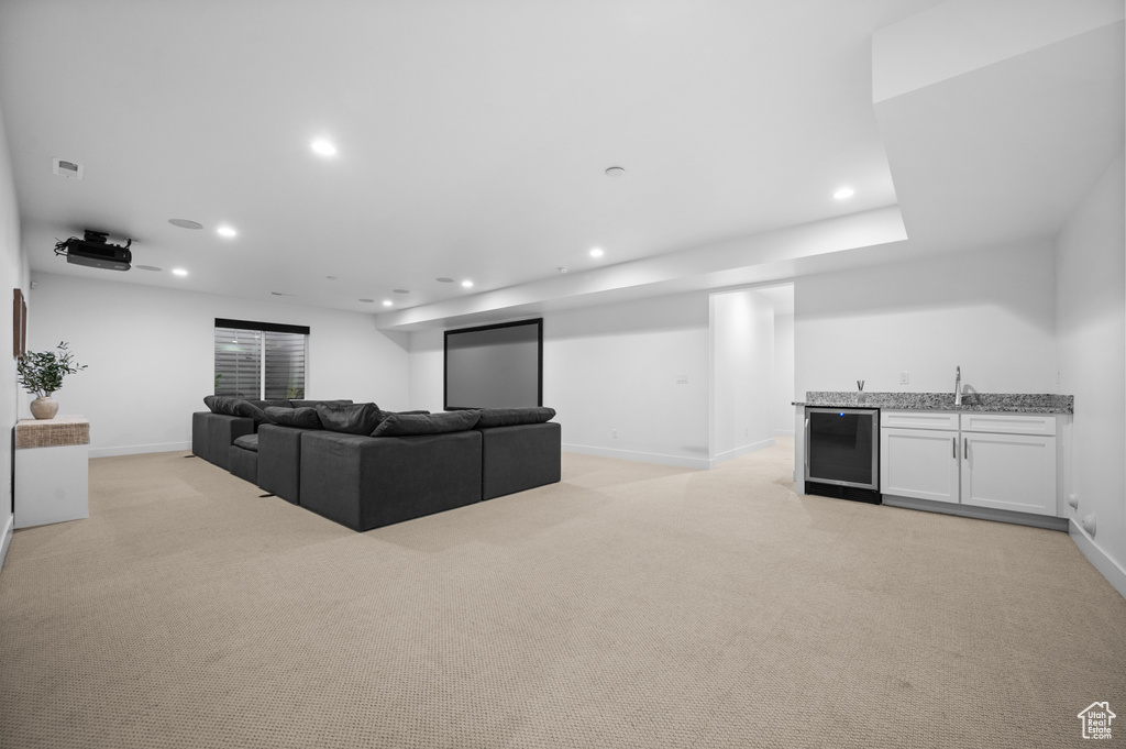 Living room featuring wet bar, recessed lighting, light carpet, baseboards, and wine cooler