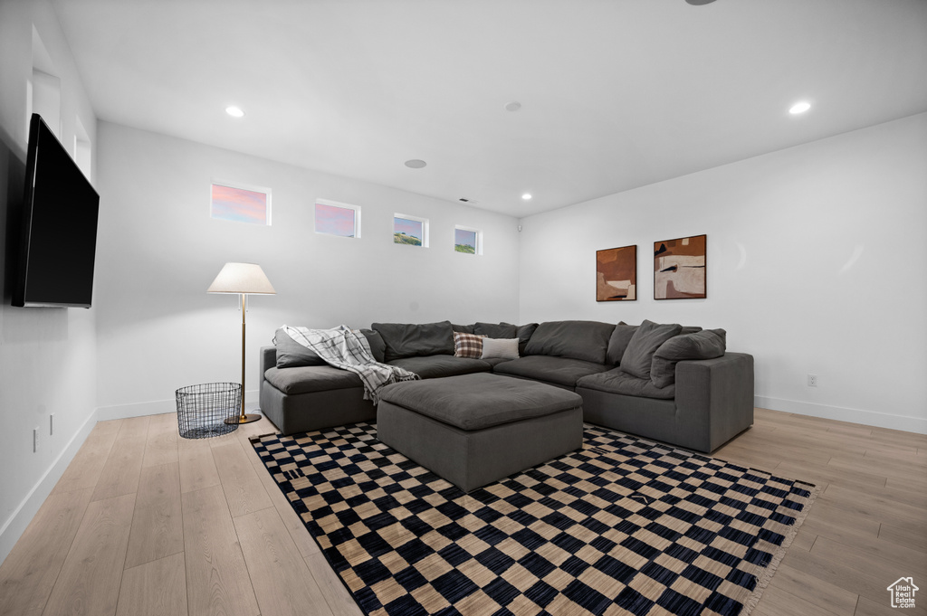 Living room with light wood-style floors, recessed lighting, and baseboards