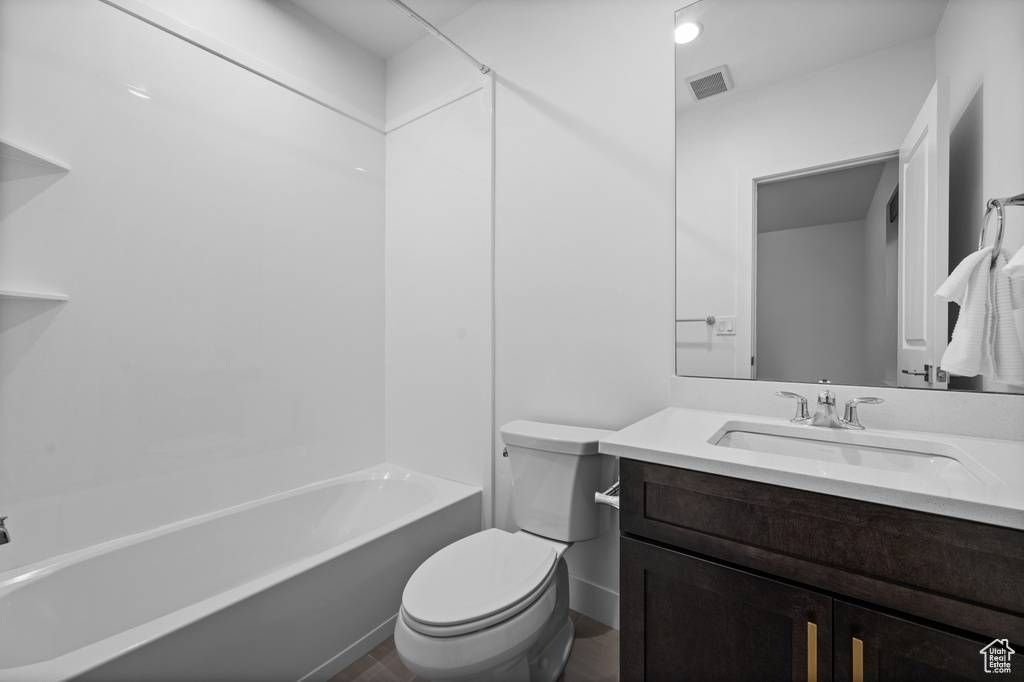 Full bath featuring toilet, vanity, washtub / shower combination, and wood finished floors
