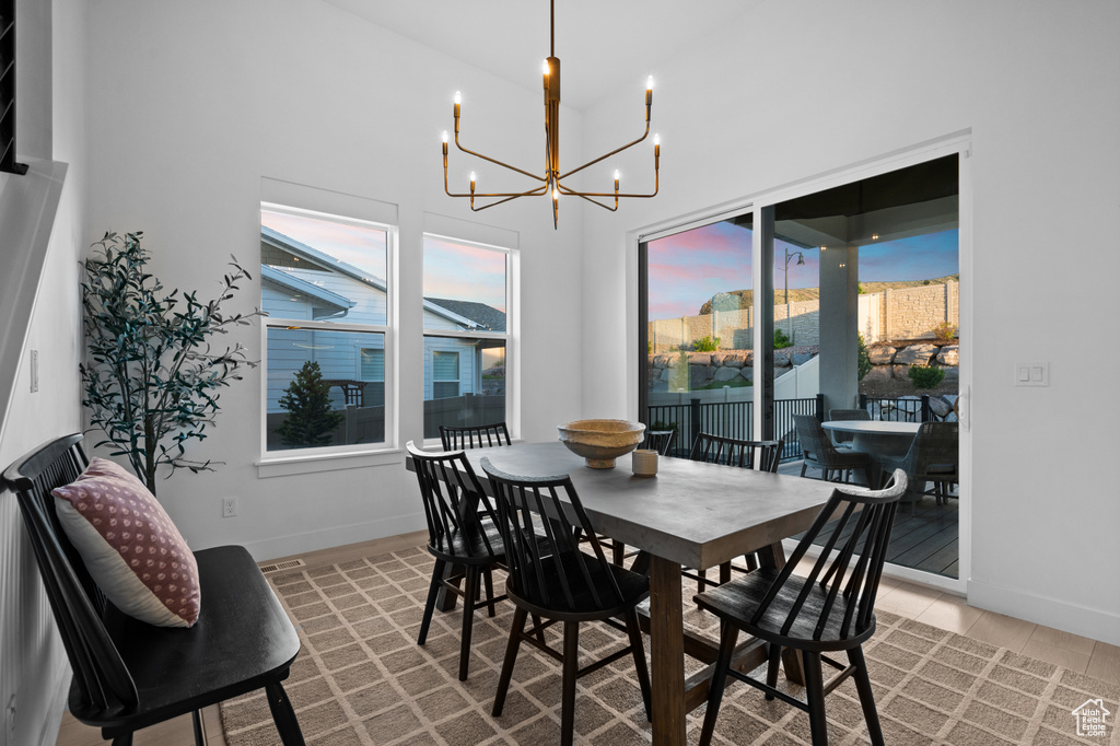 Dining room featuring a chandelier, baseboards, and a towering ceiling