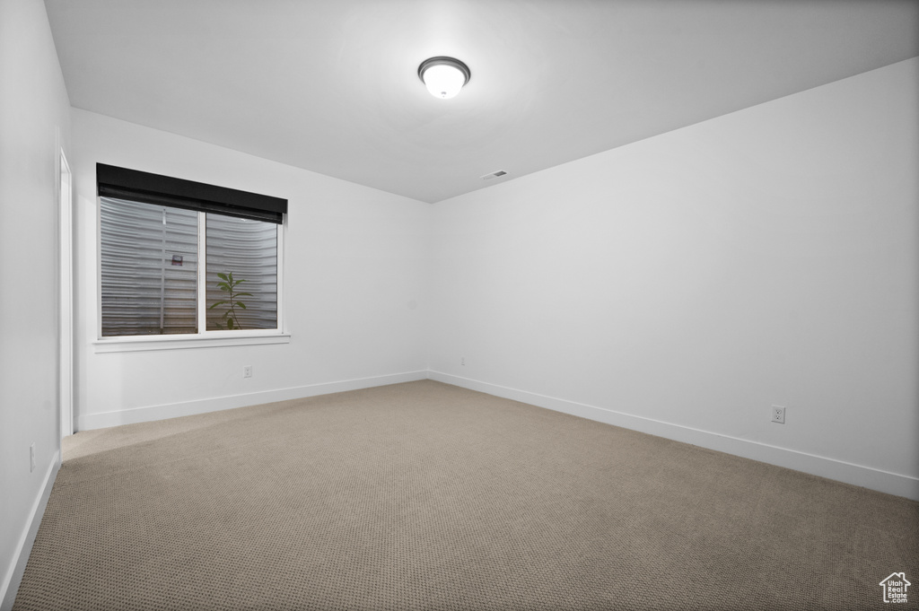 Carpeted empty room with baseboards