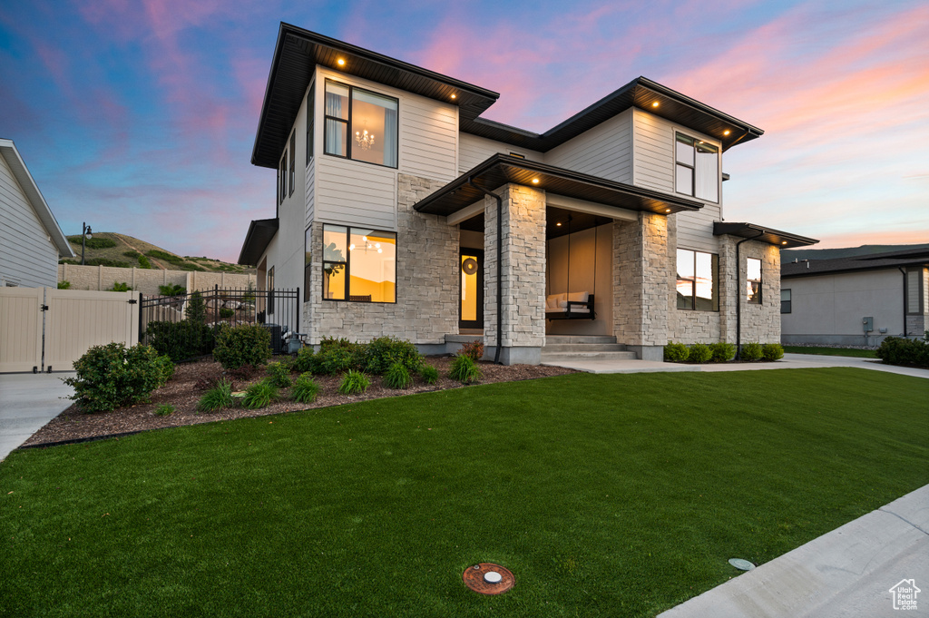 Modern home featuring stone siding and a gate