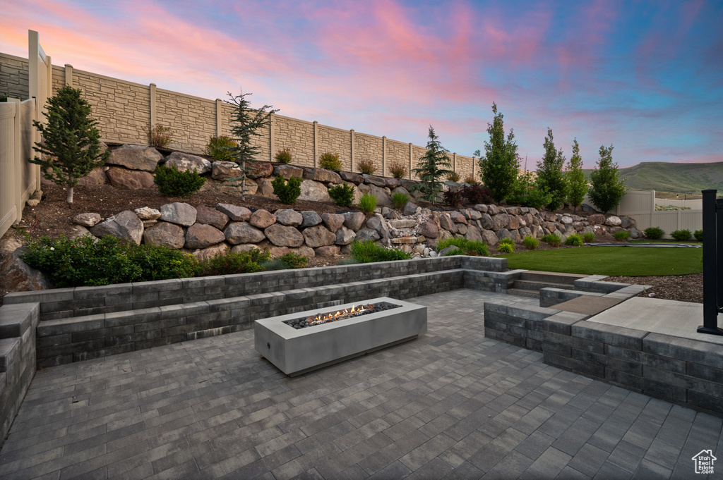 Fenced backyard with a fire pit and a patio