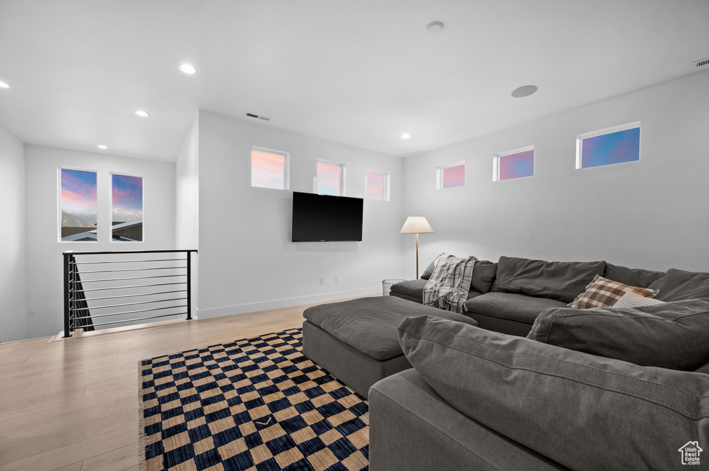 Living room with wood finished floors, recessed lighting, and baseboards