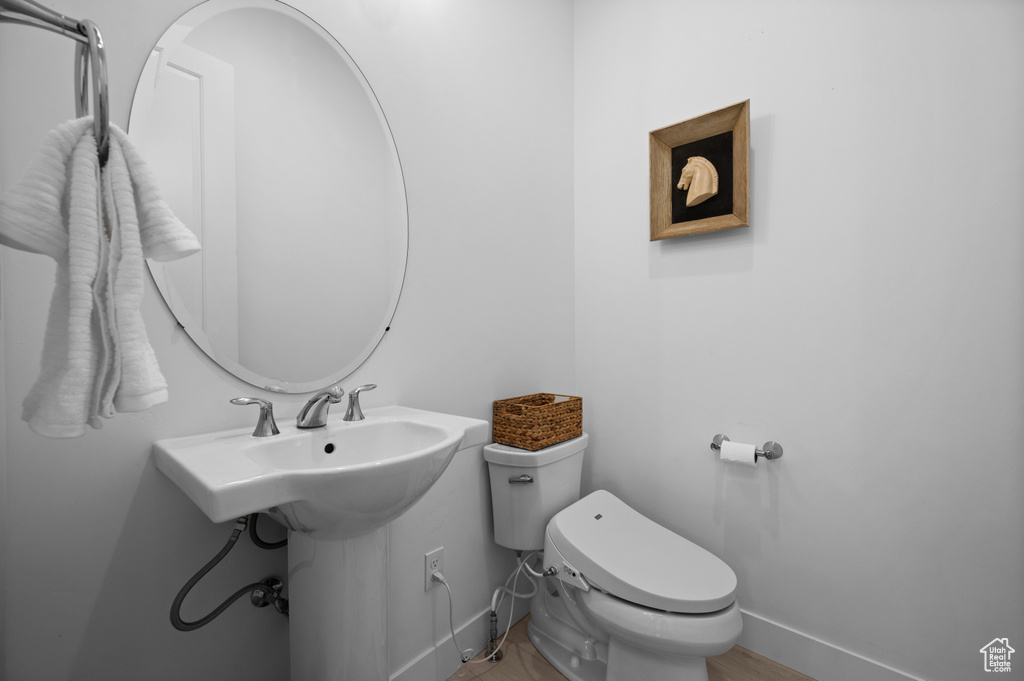 Half bath featuring toilet and baseboards