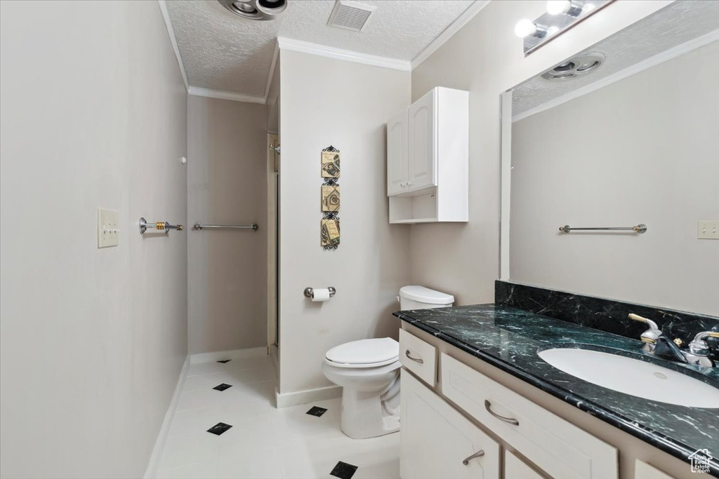 Full bathroom featuring vanity, a shower stall, toilet, baseboards, and a textured ceiling