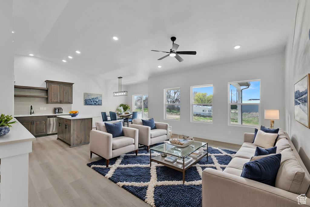 Living room with light wood-type flooring, recessed lighting, ceiling fan, and vaulted ceiling