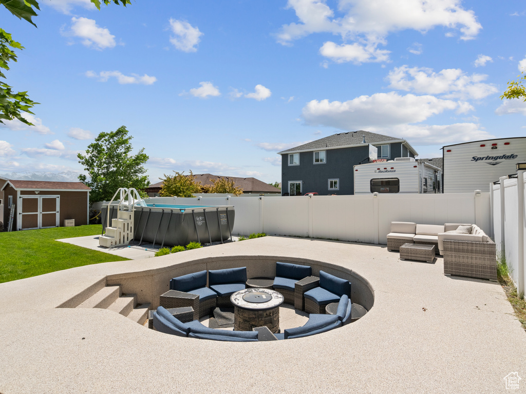 Fenced backyard with an outdoor living space with a fire pit, a patio area, and a residential view