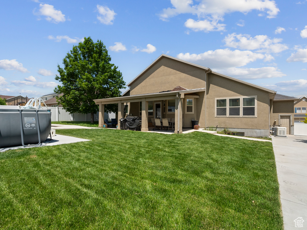 Back of house featuring stucco siding, a patio area, and cooling unit
