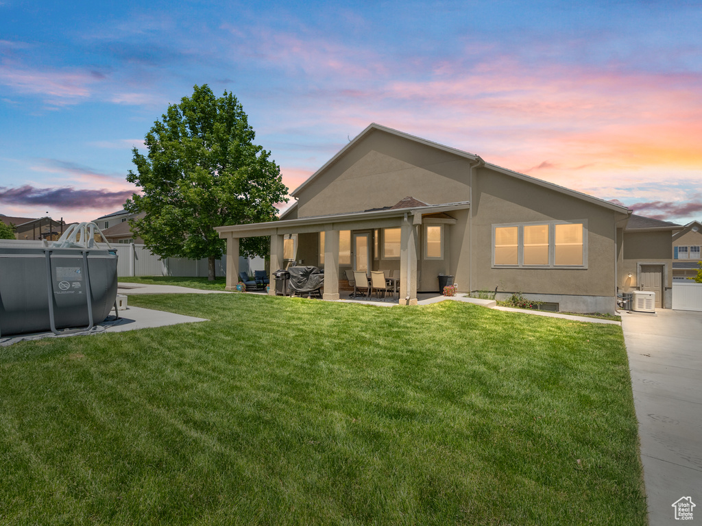 Back of house at dusk with stucco siding and a patio area